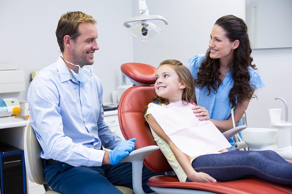 Dentist,Interacting,With,Mother,And,Daughter,While,Dental,Examination,At